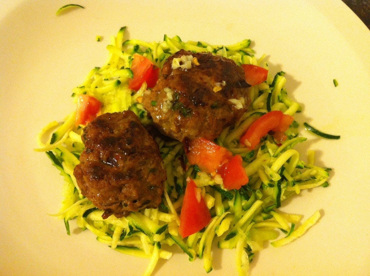 plate of healthy food with mini burgers and zucchini salad