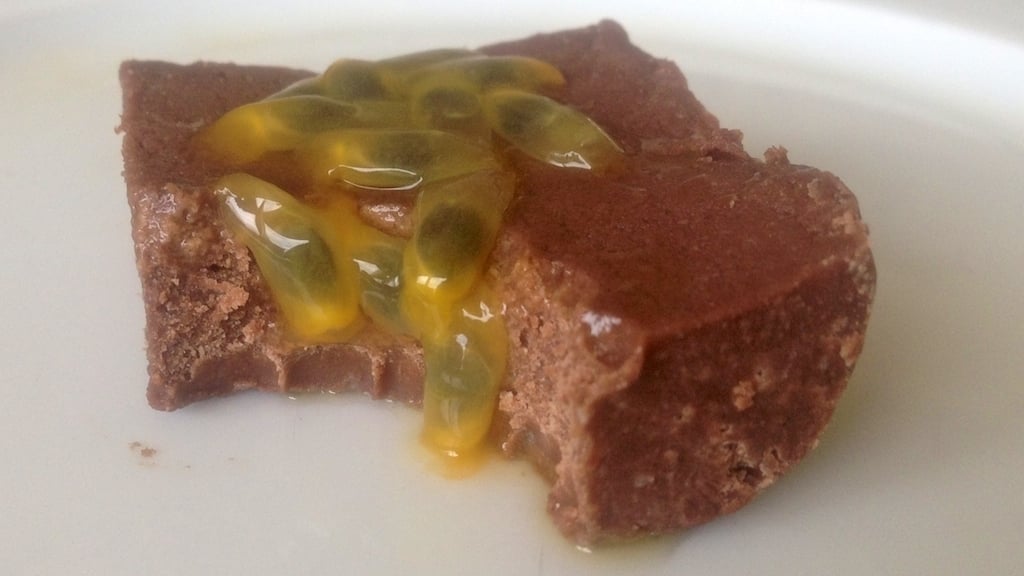 close up of a square piece of chocolate passion fruit fudge topped with bits of passion fruit seeds