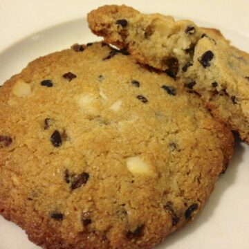 close up of two large paleo cookies with cacao nibs and macadamia and coconut