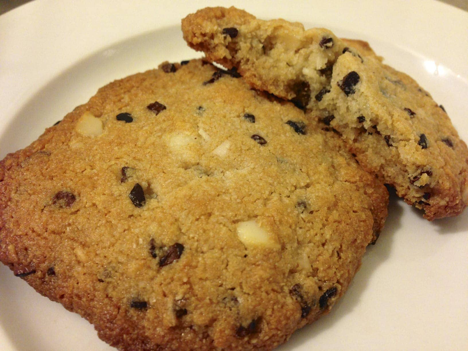 close up of two large paleo cookies with cacao nibs and macadamia and coconut