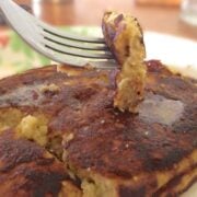 close up of stack of almond flour pancakes with one bite of pancake on a fork just above the stack