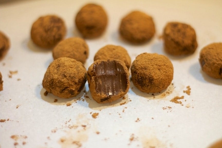 close up of dairy free Brazilian chocolate truffle known as Bridadeiro with one cut open showing inside texture
