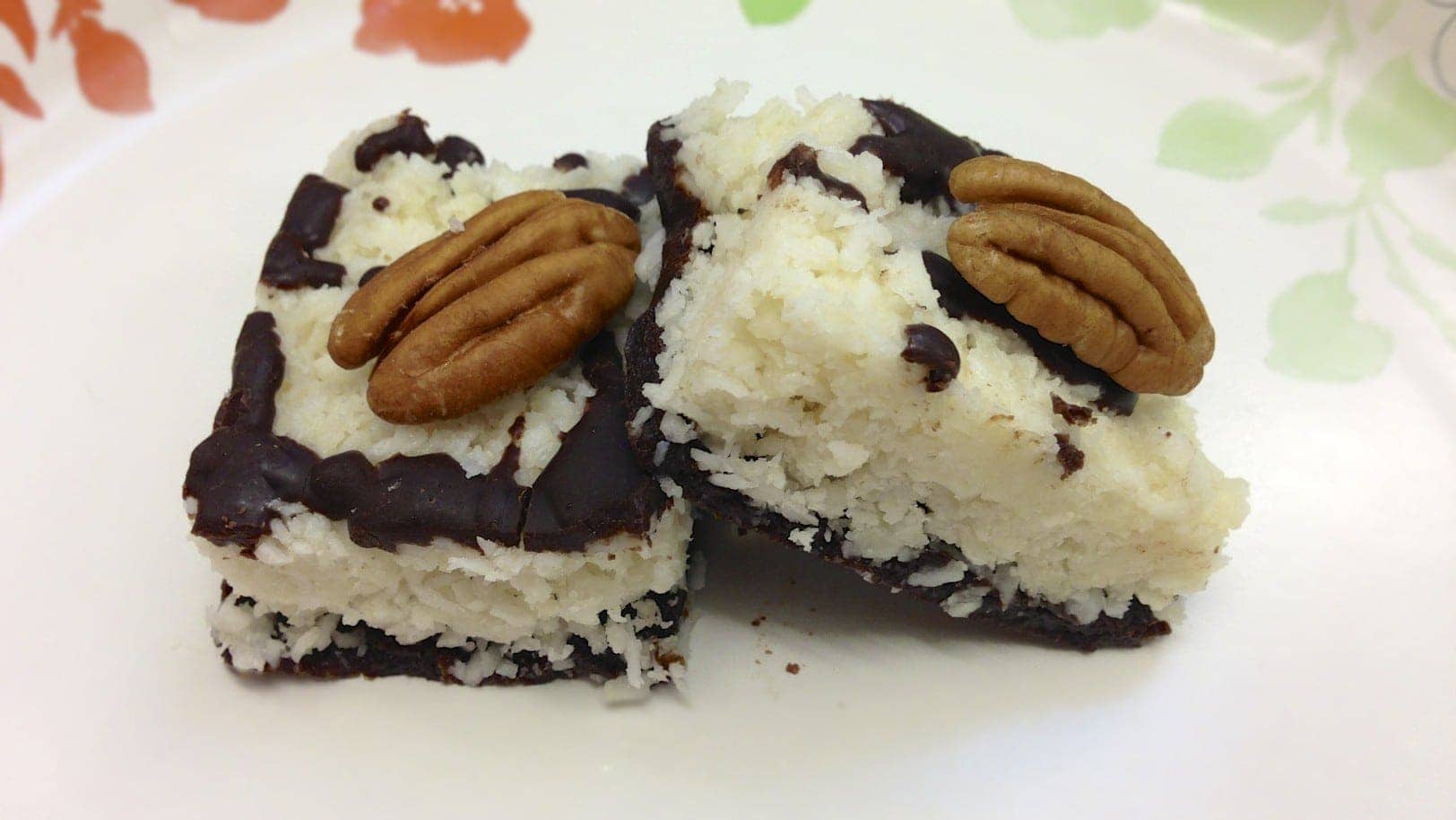 close up of paleo chocolate coconut bar topped with pecans