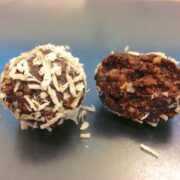 close up of two low carb paleo chocolate truffles with one piece opened up showing inside texture