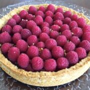 close up of large round paleo mix berry tart loaded with fresh raspberries