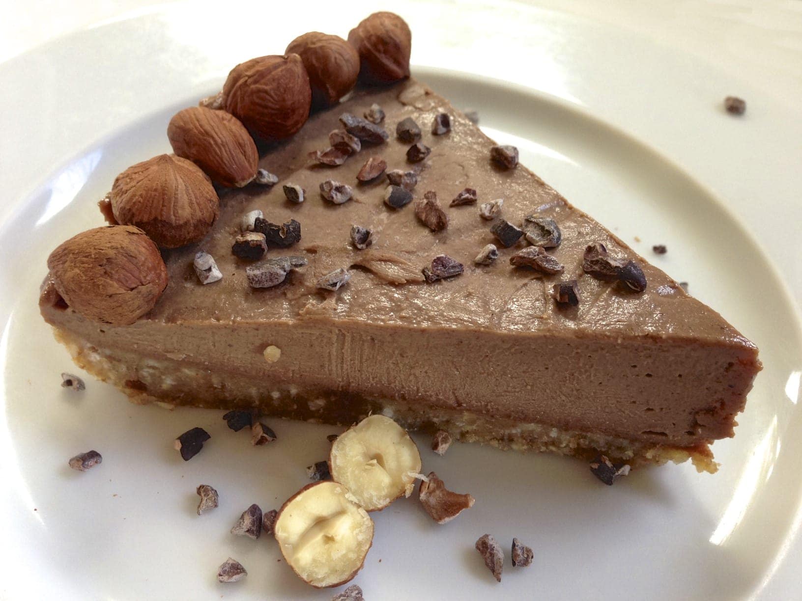 single slice of paleo hazelnut chocolate pie topped with cacao nibs 