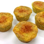close up of five grain free cheesy oregano muffins on white surface