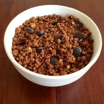 white bowl on wood table filled with paleo chocolate granola