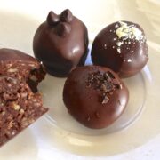 three balls of paleo chocolate pecan crunch truffles on small glass plate