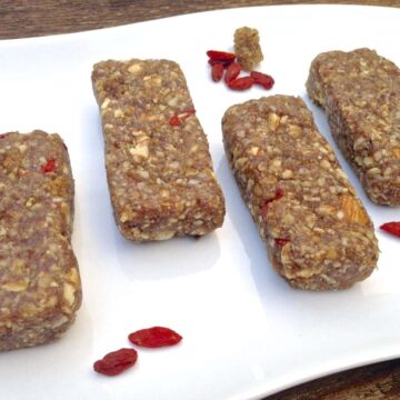 four pieces of paleo mulberry goji berry energy bars on white plate