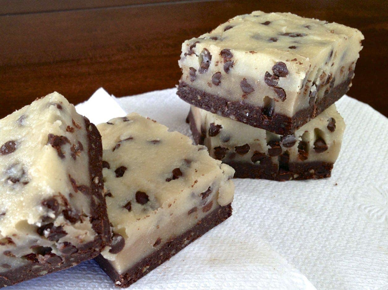 four square pieces of raw no bake chocolate chip cookie dough brownies on white napkin