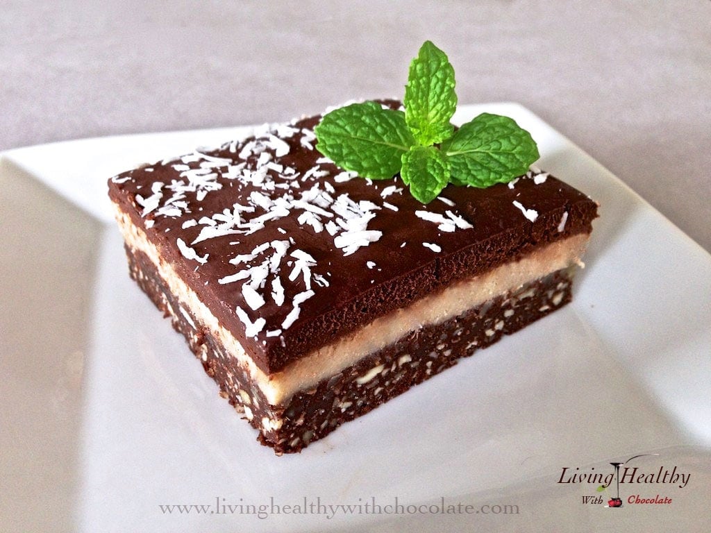 close up of chocolate macadamia triple layer brownie topped with shredded coconut and fresh mint