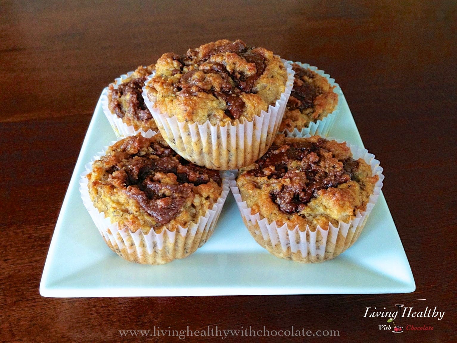 close up of five paleo nutella swirl banana muffins on a teal plate 