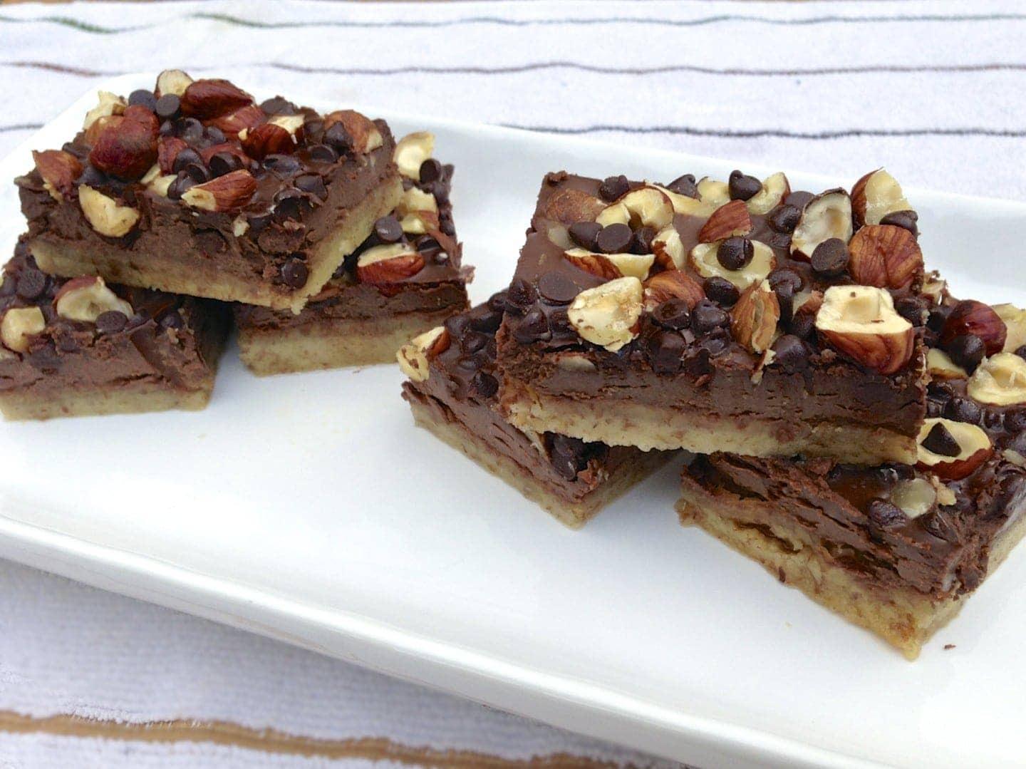 tray of paleo chocolate hazelnut cookie bars topped with chopped nuts