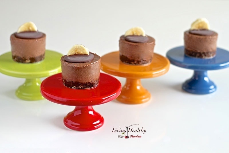mini chocolate banana fudge pies sitting on colorful serving dishes with small slice of banana on top of each