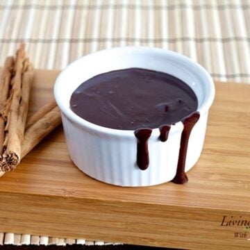small white dish filled with paleo fudge sauce on wooden cutting board