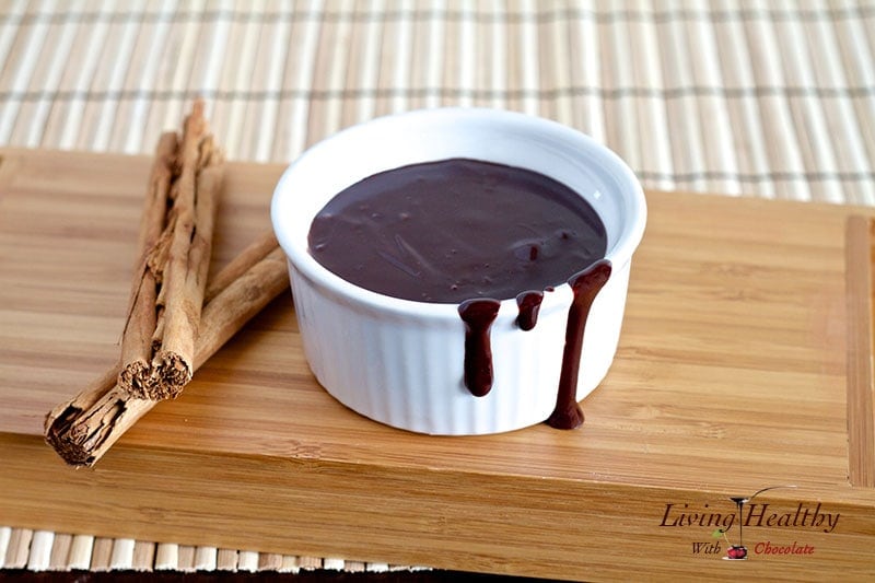 small white dish filled with paleo fudge sauce on wooden cutting board