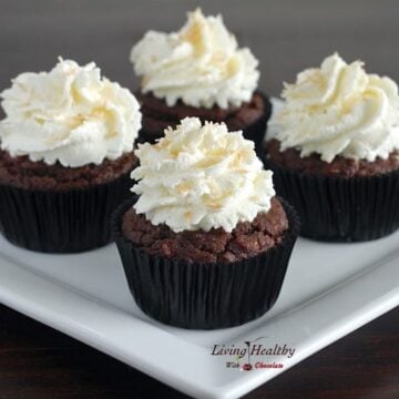 plate with four paleo coconut cupcakes topped with whipped cream