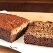 loaf of paleo black bottom banana bread on with three slices sitting sideways  on white plate