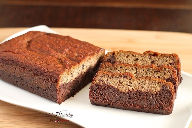 loaf of paleo black bottom banana bread on with three slices sitting sideways  on white plate