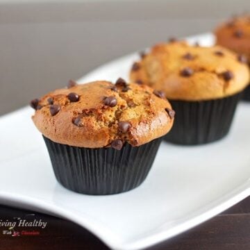 close up of two paleo flourless chocolate chip muffins on white plate.