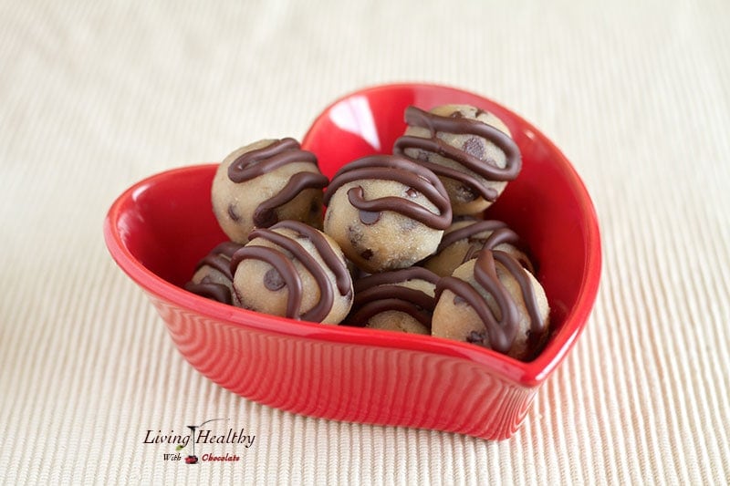 red heart shaped bowl with paleo gluten free cookie dough bite topped with stripes of chocolate