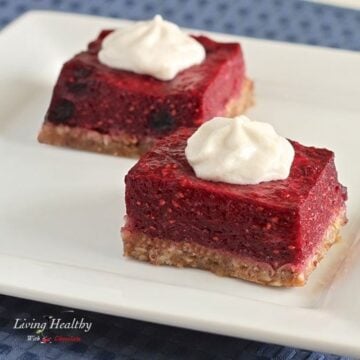 square plate with two paleo low carb berry bars topped with whipped cream