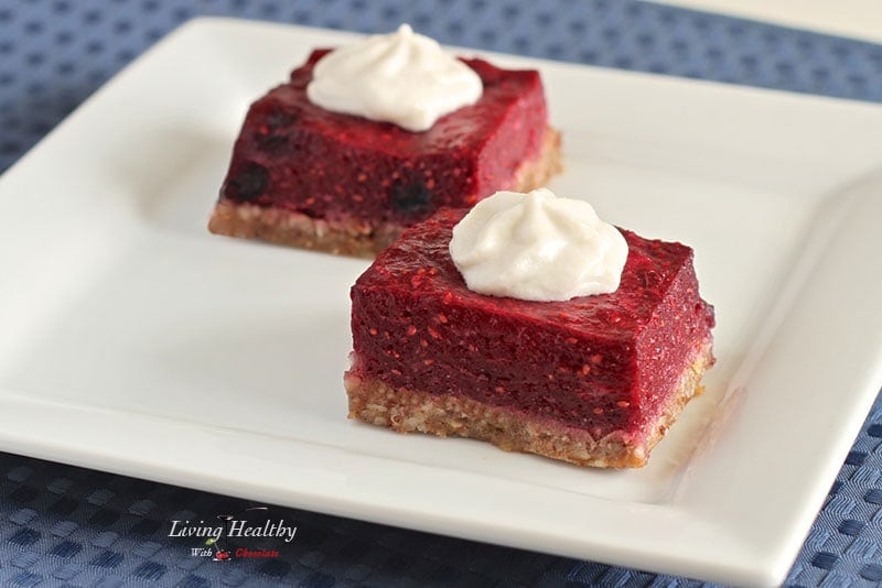 square plate with two paleo low carb berry bars topped with whipped cream 