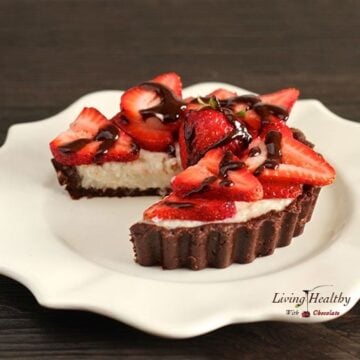 round plate with paleo strawberry coconut cream pie with one slice cut out and topped with slices of fresh strawberries