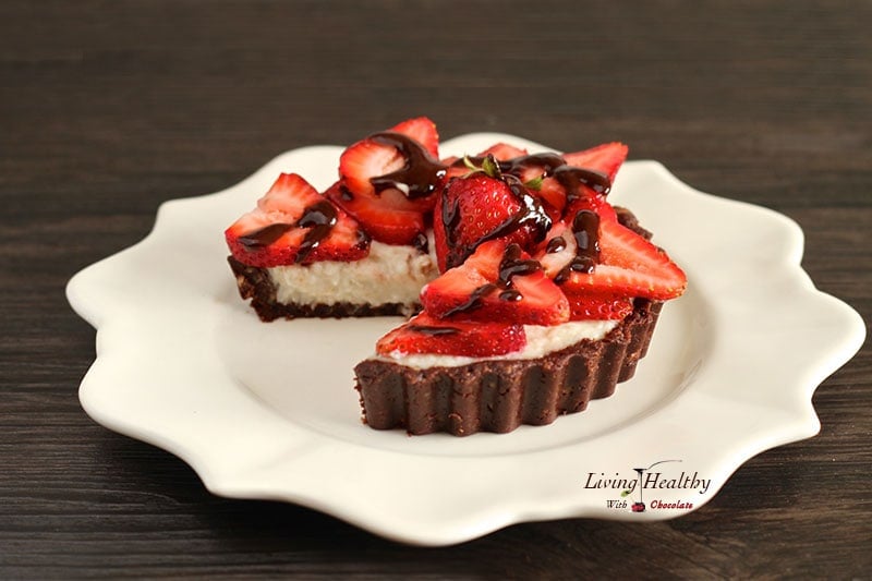 round plate with paleo strawberry coconut cream pie with one slice cut out and topped with slices of fresh strawberries 