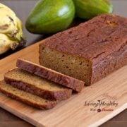 loaf of avocado banana bread on cutting board with bananas and avocado in background