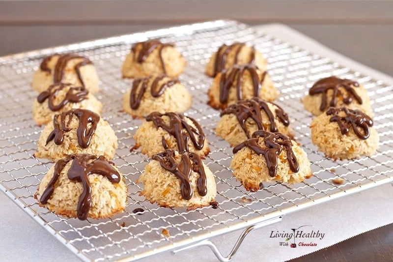 wire cooling rack with rows of coconut orange macaroons drizzled with chocolate
