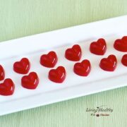 red heart shaped homemade fruit snacks rectangular plate on green placemat