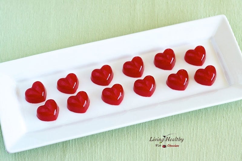 red heart shaped homemade fruit snacks rectangular plate on green placemat