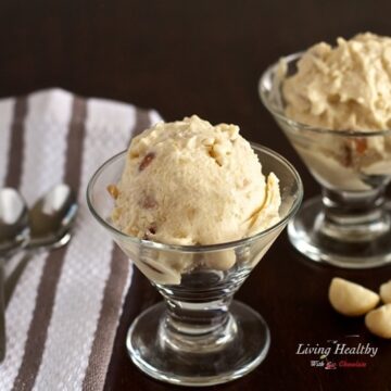 two small glass dishes with honey roasted macadamia nut ice cream with stripped napkin on left with two spoons