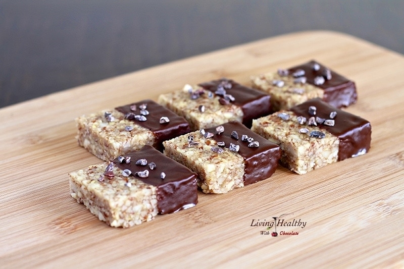 wooden cutting board with several paleo nut krispy treats lined up