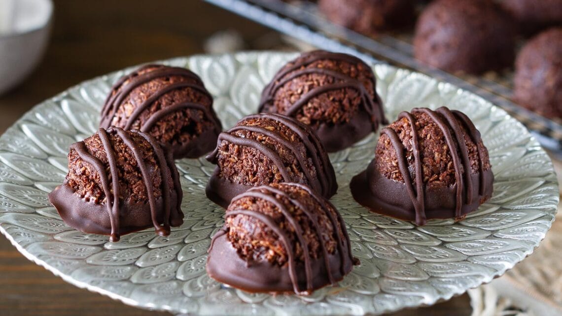 cake stand full of chocolate coconut macaroons dipped and drizzled in chocolate