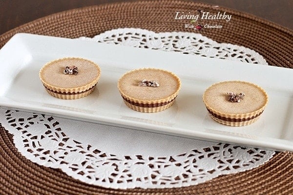 three paleo inside out almond butter cups on a white rectangular with white lace placemat underneath 