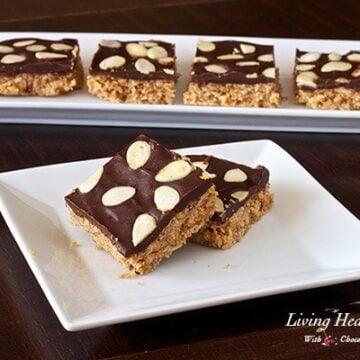 white plate with two square pieces of almond macaroon bar with four more bars in background on long plate