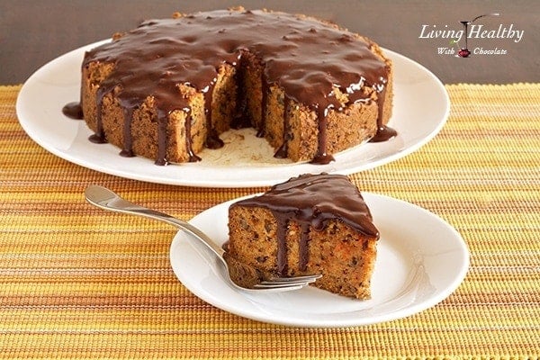 slice of paleo carrot cake topped with chocolate sauce in foreground with remaining cake in background 