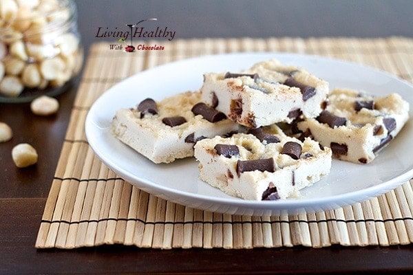 plate of chocolate chunk macadamia nut fudge bars topped with chocolate chips