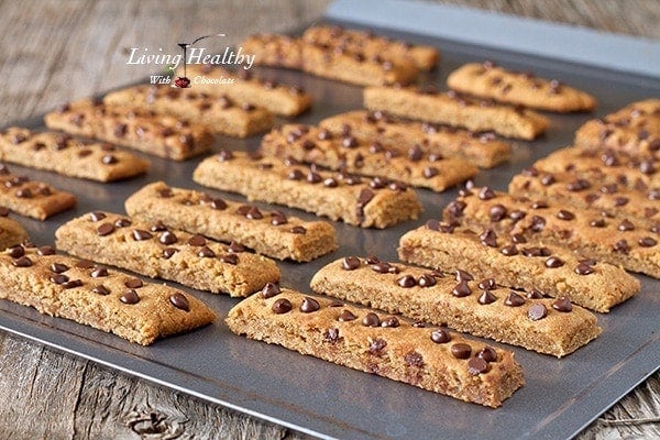 baking pan with rows of chocolate chip cookie sticks topped with chocolate chips