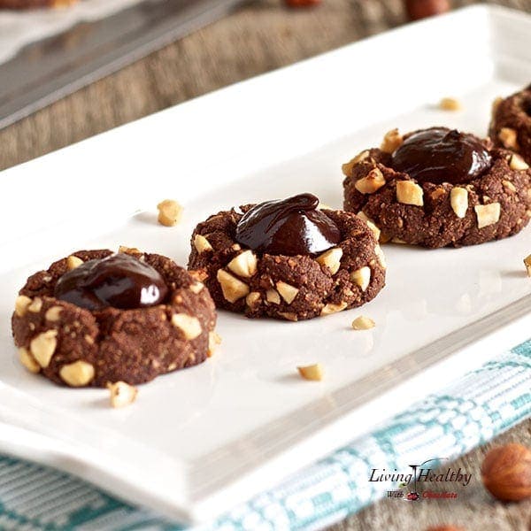 close up of a narrow white serving dish with four chocolate hazelnut bloom cookies 