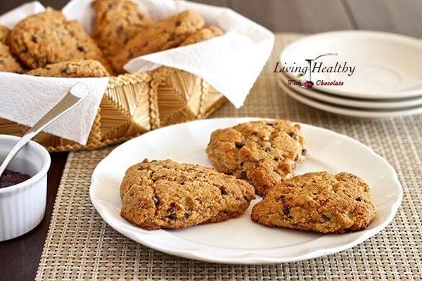 plate with three chocolate chip scones with basket in background with more scones