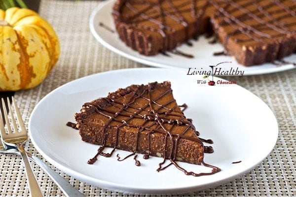 slice of paleo triple chocolate pumpkin pie drizzled with chocolate and remaining pie in background 