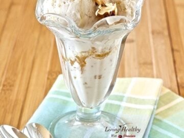 tall glass serving dish on two colorful napkins filled with paleo maple walnut ice cream with two spoons on side