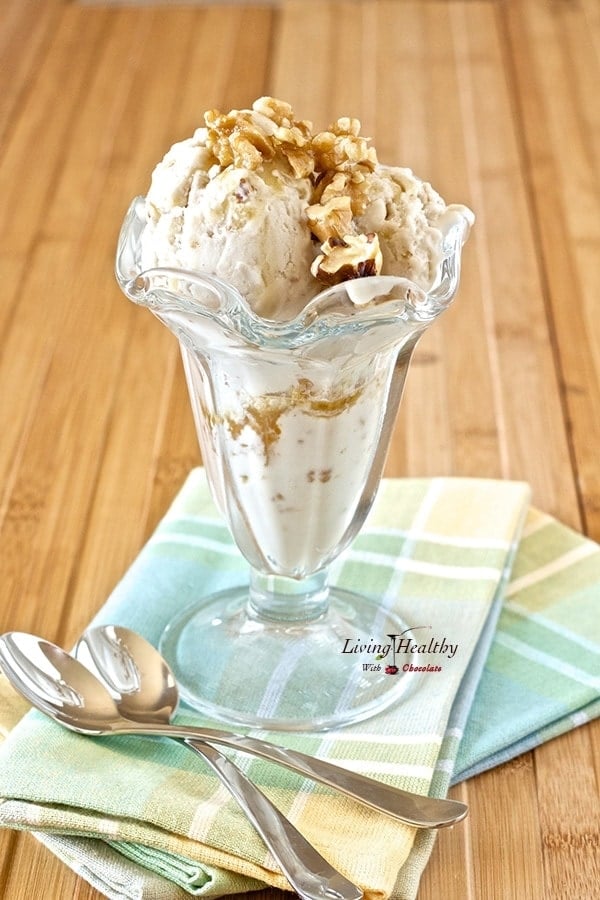 tall glass serving dish on two colorful napkins filled with paleo maple walnut ice cream with two spoons on side