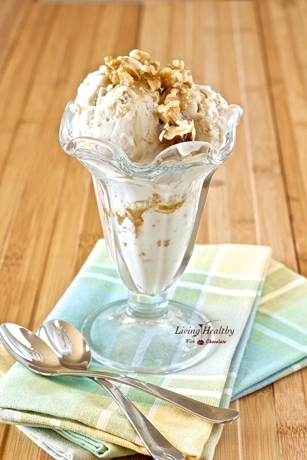 tall glass serving dish on two colorful napkins filled with paleo maple walnut ice cream with two spoons on side