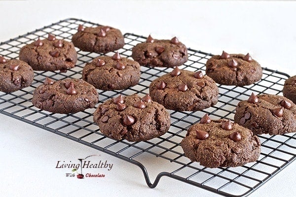 wire rack with several rows of paleo nutella filled double chocolate chip cookies topped with chocolate chips