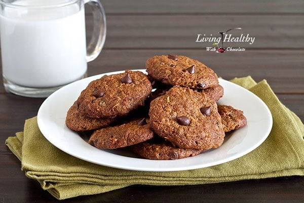 plate of coconut chocolate chip cookies with glass of milk in the background